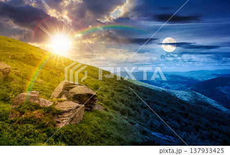 day meet night on summer solstice landscape in mountains. sun and moon over grassy hill with huge stones under the epic sky. wonderful nature background. picture of a hillside meadow near the peak 137933425