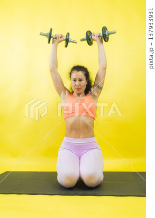 Fit woman performing full body workout with dumbbells Fit woman performing full body workout with dumbbells 137933931