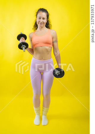 Woman exercising with dumbbells for fitness and strength Woman exercising with dumbbells for fitness and strength 137933971