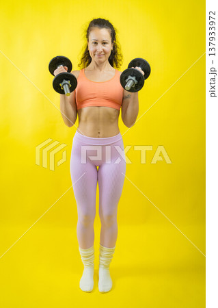 Woman exercising with dumbbells for fitness and strength 137933972