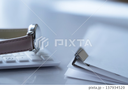 テーブルに置かれた書類と腕時計と電卓 テーブルに置かれた書類と腕時計と電卓 137934520