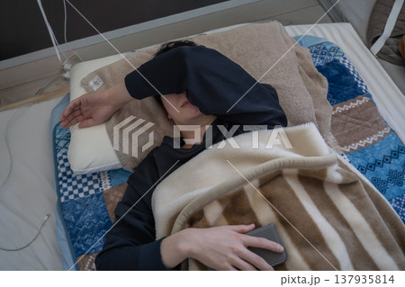 布団で眠る男性 137935814