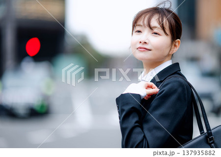 カバンを持って歩く若い女性 137935882