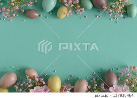 Pastel Easter Eggs and Flowers on Teal Background. Festive Spring Flatlay Pastel Easter Eggs and Flowers on Teal Background. Festive Spring Flatlay 137936464