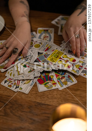 Tarot cards and fortune telling. Soothsayer predicting future with tarot cards. Unrecognizable mysterious fortuneteller holding tarot cards forecasting future for client. Future reading esoteric 137937139