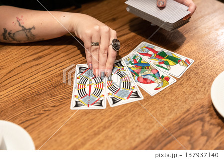 Tarot cards and fortune telling. Soothsayer predicting future with tarot cards. Unrecognizable mysterious fortuneteller holding tarot cards forecasting future for client. Future reading esoteric Tarot cards and fortune telling. Soothsayer predicting future with tarot cards. Unrecognizable mysterious fortuneteller holding tarot cards forecasting future for client. Future reading esoteric 137937140
