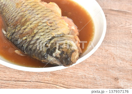 braised silver barb or carp fish in sweet and salty black soy sauce soup on plate 137937176