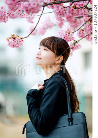桜を背景にした若い女性 137937224