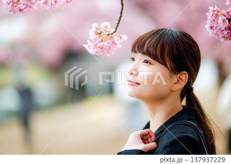 桜を背景にした若い女性 137937229
