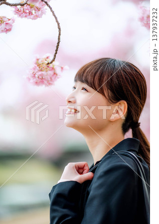 桜を背景にした若い女性 137937232
