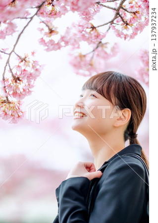 桜を背景にした若い女性 137937234