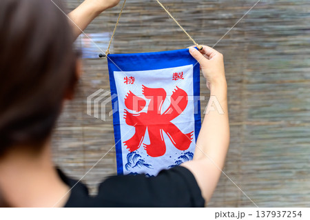 かき氷の特製旗を竹簾の前で持つ人 137937254