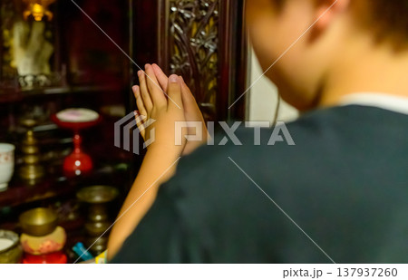 仏壇の前で手を合わせる子供の後ろ姿 仏壇の前で手を合わせる子供の後ろ姿 137937260