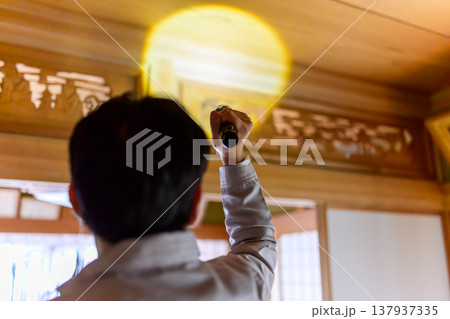 和風建築の天井を懐中電灯で照らす作業員 和風建築の天井を懐中電灯で照らす作業員 137937335