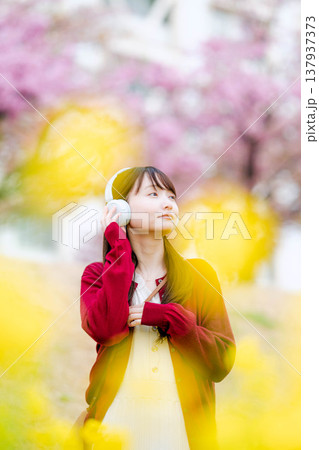 桜の中でヘッドホンで音楽を聴く若い女性 桜の中でヘッドホンで音楽を聴く若い女性 137937373