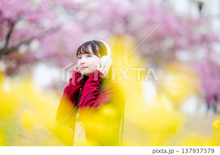 桜の中でヘッドホンで音楽を聴く若い女性 桜の中でヘッドホンで音楽を聴く若い女性 137937379