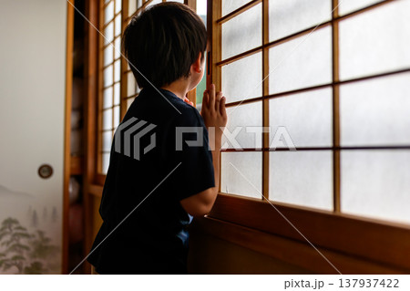 障子越しに外を伺う子供の後ろ姿 137937422