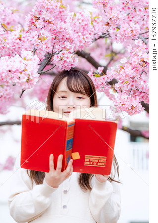 桜の木の前で読書をする若い女性 桜の木の前で読書をする若い女性 137937710
