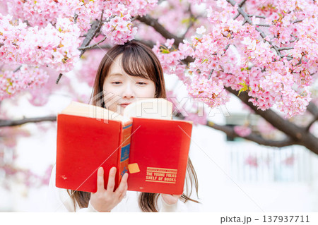 桜の木の前で読書をする若い女性 桜の木の前で読書をする若い女性 137937711