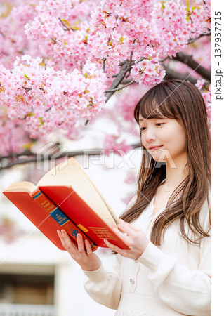 桜の木の前で読書をする若い女性 桜の木の前で読書をする若い女性 137937715
