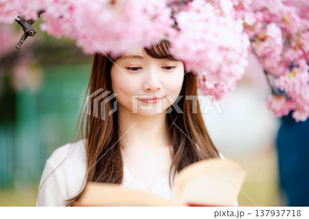 桜の木の前で読書をする若い女性 137937718