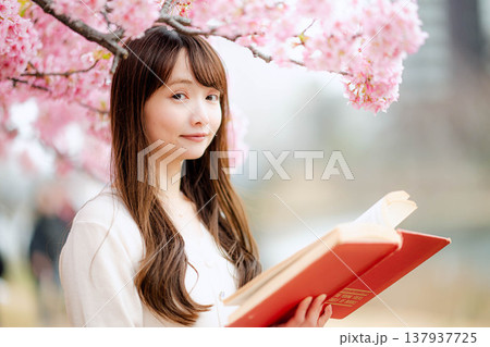 桜の木の前で読書をする若い女性 137937725