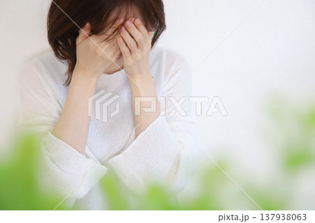 顔を覆って悩む女性のイメージ 137938063