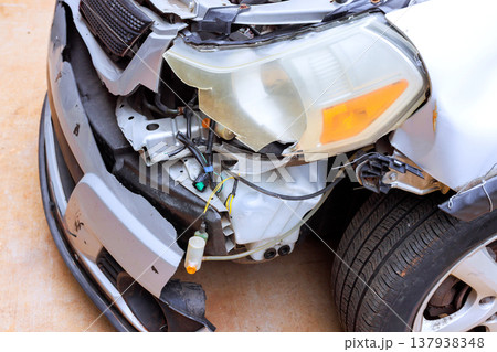 Car with damaged front is seen at roadside with broken parts exposed wires after crash. Car with damaged front is seen at roadside with broken parts exposed wires after crash. 137938348