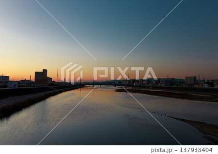 夕暮れの川と街並みのシルエット 137938404