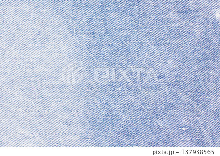 Classic blue denim texture with a distinct diagonal twill weave. Faded indigo tones and natural wear patterns create a versatile, vintage textile background 137938565
