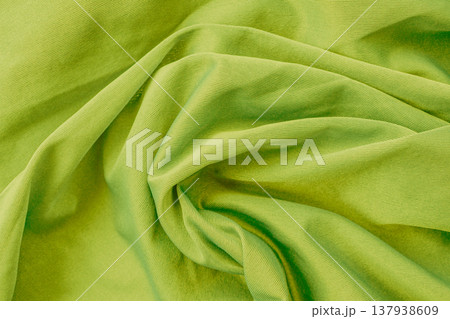 Vibrant lime green cotton texture with heavy organic folds. The dense, denim-like fabric features a visible twill weave and deep shadows, creating an energetic background Vibrant lime green cotton texture with heavy organic folds. The dense, denim-like fabric features a visible twill weave and deep shadows, creating an energetic background 137938609