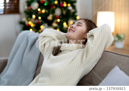 young woman leaning on the sofa half asleep and smiling young woman leaning on the sofa half asleep and smiling 137938921