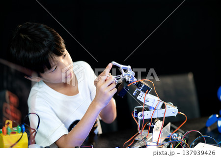Kid doing science invention experiment on mechanical robots Kid doing science invention experiment on mechanical robots 137939426