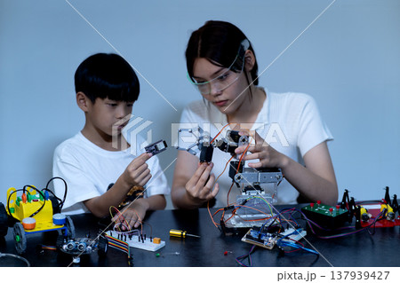young woman and a boy Amateurs inventor tweaking young woman and a boy Amateurs inventor tweaking 137939427