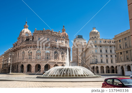Genoa, liguria, italy. May 18,2024. Piazza de ferrari, genoa's main square, featuring an iconic fountain with historic palace buildings under a clear blue sky Genoa, liguria, italy. May 18,2024. Piazza de ferrari, genoa's main square, featuring an iconic fountain with historic palace buildings under a clear blue sky 137940336