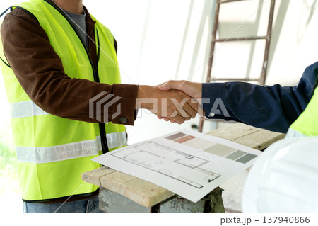 Builder and supervisor hand in hand to show agreement happiness Builder and supervisor hand in hand to show agreement happiness 137940866