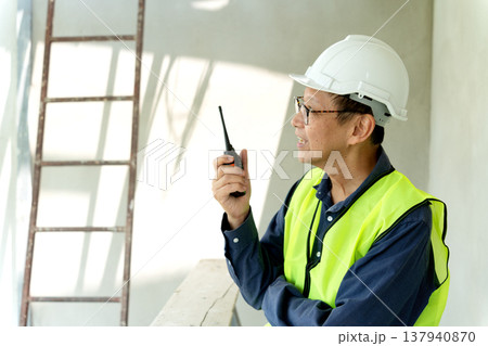 construction site manager is using radio to order construction 137940870