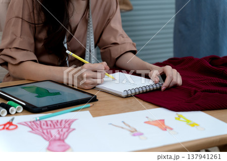 young woman designer drawing clothes using electronic  pencil 137941261
