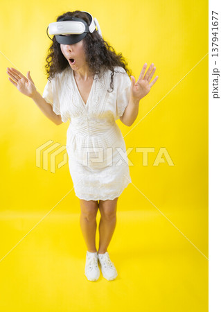 Woman experiencing virtual reality with a surprised expression 137941677