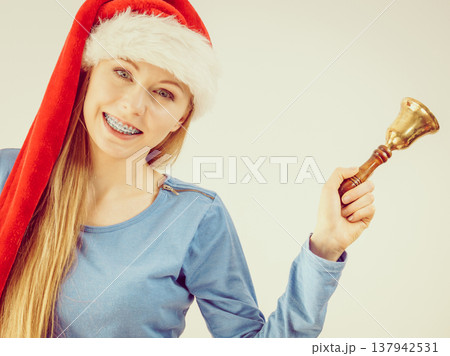 Christmas woman holding bell. 137942531