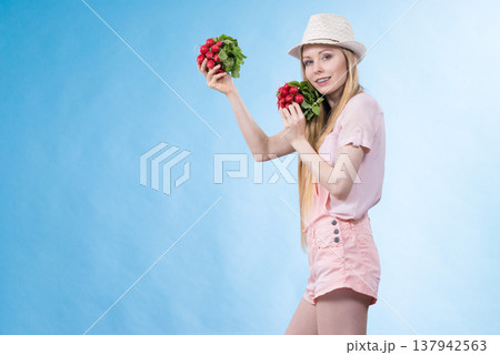 Young woman holding radish Young woman holding radish 137942563