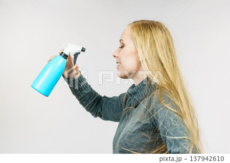 Girl long hair holding spray bottle 137942610
