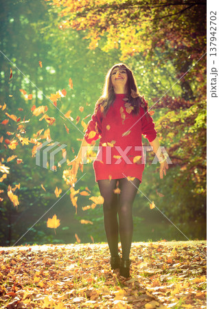 Joyful girl having fun with leaves in autumnal park. Joyful girl having fun with leaves in autumnal park. 137942702