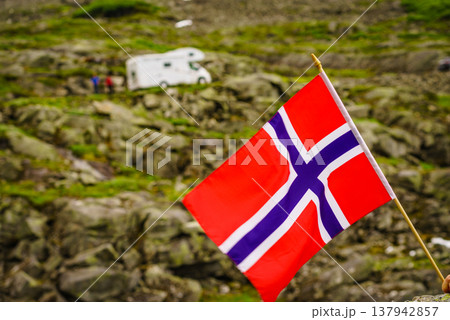 Norwegian flag and camper car in mountains Norwegian flag and camper car in mountains 137942857