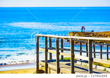 Beach with wooden path to sea water. Beach with wooden path to sea water. 137942894