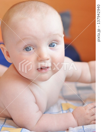 Adorable Baby Smiling While Lying on Blanket 137942940