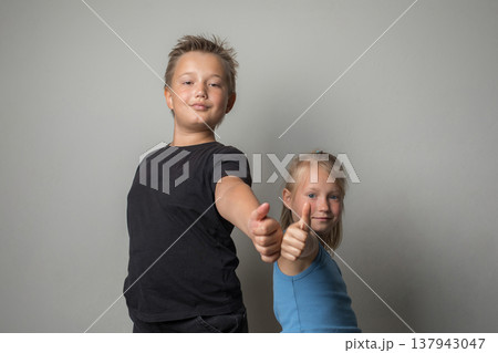 a boy and a girl showing thumbs up a boy and a girl showing thumbs up 137943047