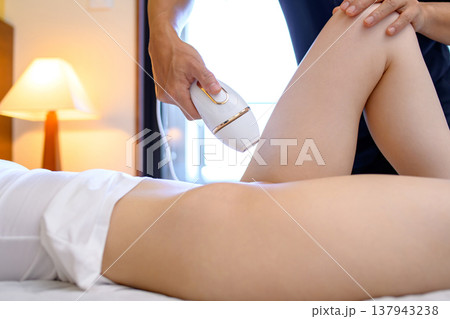 VIO脱毛をパートナー(彼氏、夫)に手伝ってもらう女性　家庭用脱毛器　真横視点　 137943238