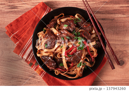 Udon noodles with beef in Mongolian style, with green onions and vegetables, homemade, on a wooden table, Udon noodles with beef in Mongolian style, with green onions and vegetables, homemade, on a wooden table, 137943260