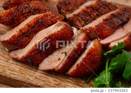 Roast duck breast, sliced, on a wooden chopping board,close-up, no people, 137943263
